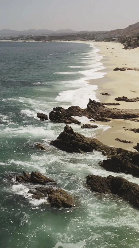Vertical Long of Sea Waves onto Rocks Stock Footage 285566128