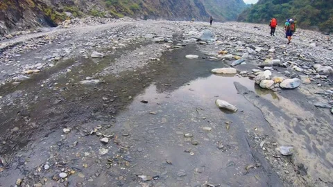 Vertical look up from river water to slow motion of group hikers wearing profess Stock-Footage 266501788