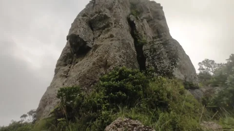 Vertical look up view to a boulder of rock shapes like a human face head during  Stock Footage 245446766