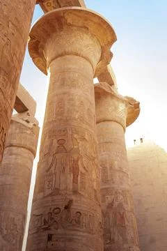 Vertical low angle close up view of a row of columns with carved hieroglyph.. Stock Photos