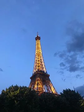 Vertical low angle of the Eiffel tower with yellow lighting in the evening 写真素材