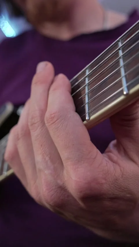 Vertical low angle perspective shot along the guitar neck as musician moves Stockbeeldmateriaal 345211310