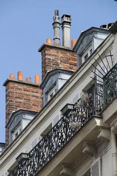 Vertical low angle shot of a building with balconies and chimneys in Paris, Fran Stock Photos