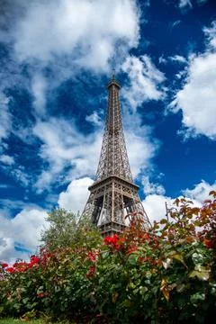 Vertical low angle shot of the Eiffel Tower against a blue cloudy sky in Paris, 스톡 사진