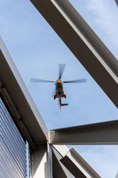 Vertical low angle shot of a helicopter flying over the roof of the Paris 스톡 사진
