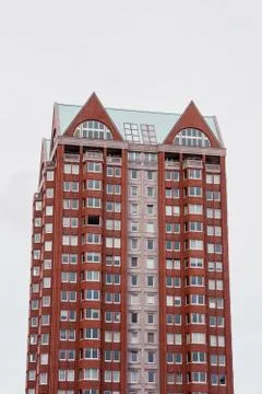 A vertical low angle shot of a high-rise red building isolated on a white bac Stock Photos