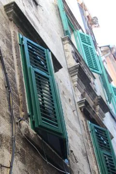 Vertical low angle shot of an old building with green window blinds in Zagreb Fotos de archivo