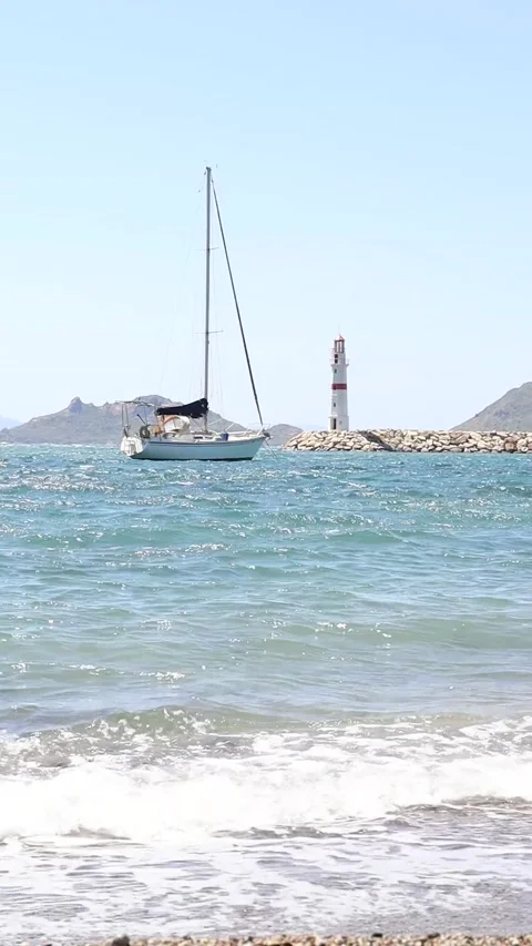 Vertical Low Angle shot of Sailboat and Lighthouse Stock Footage 236661182