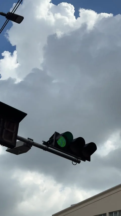Vertical Low Angle View Of Green Traffic Light Flashing Against Cloudy Blue Sky Stock Footage 346596842