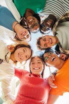 Vertical low angle view of a group of multiracial friends standing on a circle Stock Photos