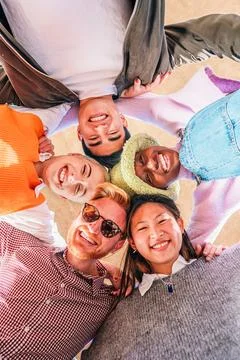 Vertical low angle view of a multiracial happy young friends having fun and Stock Photos