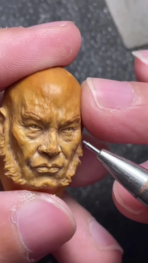 Vertical Macro Close Up Hands Carving Detailed Old Man Portrait on Fruit Pit Stock Footage 327043527