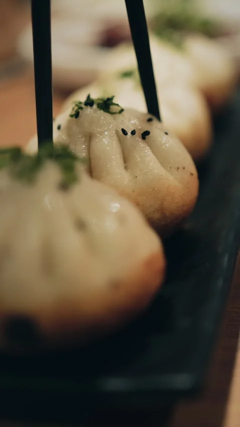Vertical macro close-up of pan-fried Chinese bun with sesame and green onion Video stock 333898176
