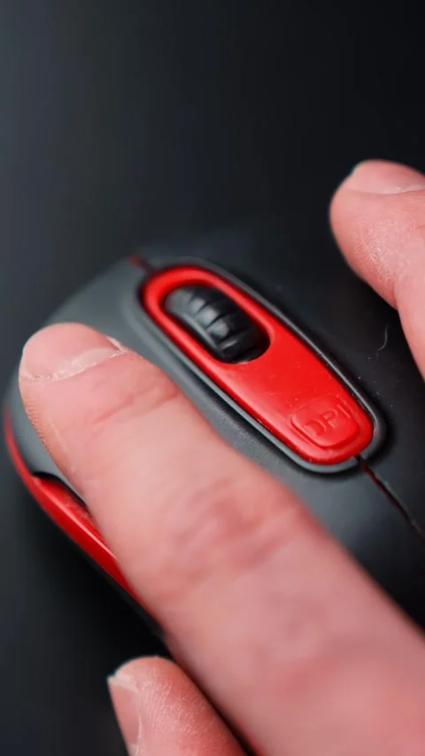 Vertical macro of a finger pressing the DPI button on a red and black computer Stock Footage 329002382