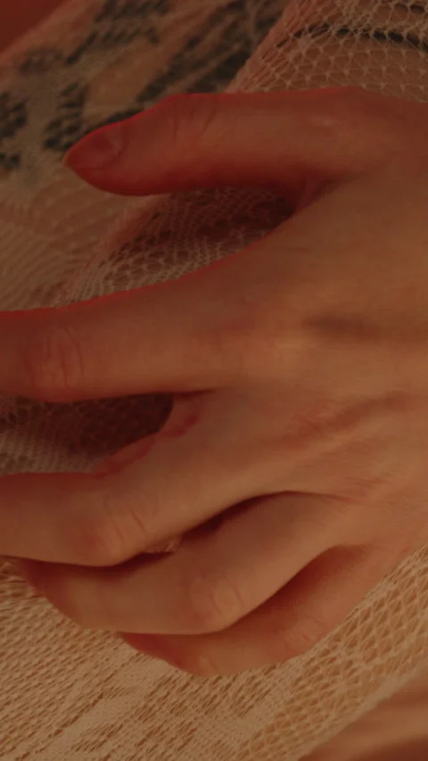 Vertical macro of a hand pulling and caressing the white stockings being worn Stock Footage 333613229