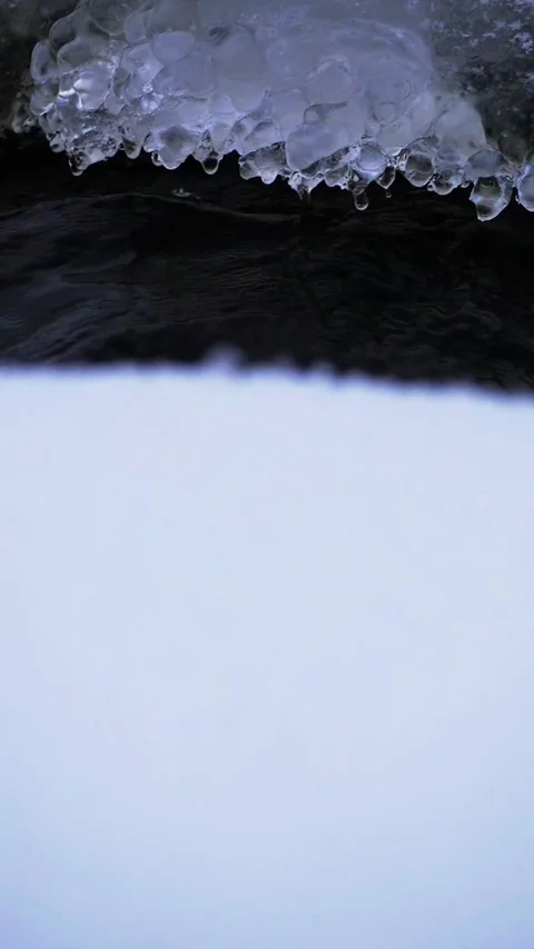 Vertical Macro of Icicles and Frozen Water Formations Over a Dark Stream Copy Sp Stock Footage 326665963