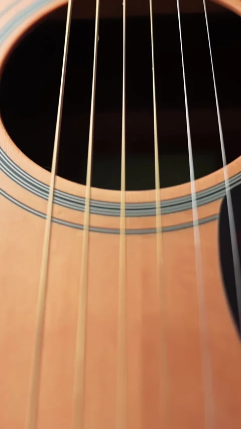 Vertical macro move upward from the acoustic guitar bridge along the strings to 스톡 동영상 331318116