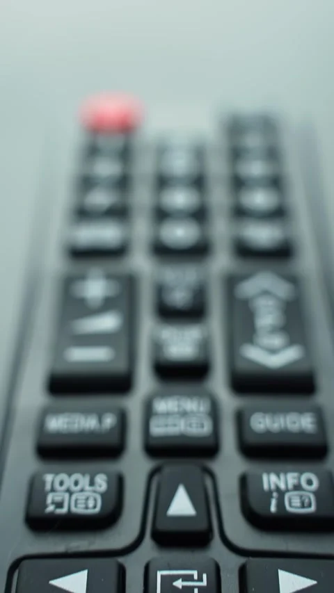 Vertical macro pan down a TV remote control from top to bottom, shallow depth 스톡 동영상 331108317