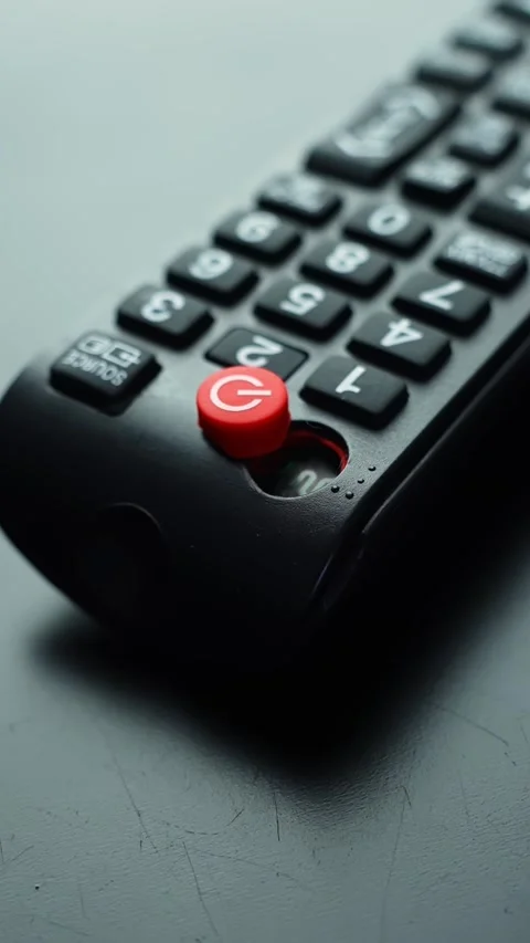 Vertical macro shot of a black TV remote with red power button in sharp focus Stock Footage 331108416