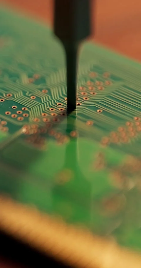 Vertical Macro Shot of Precision Tool Engraving Patterns on Green Circuit Board Stock Footage 336460117