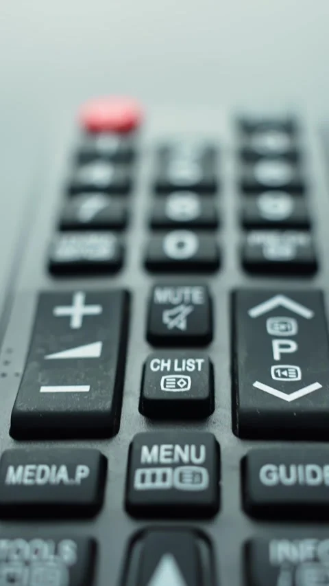 Vertical macro shot of a TV remote control showing directional arrow and menu Stock Footage 329598809