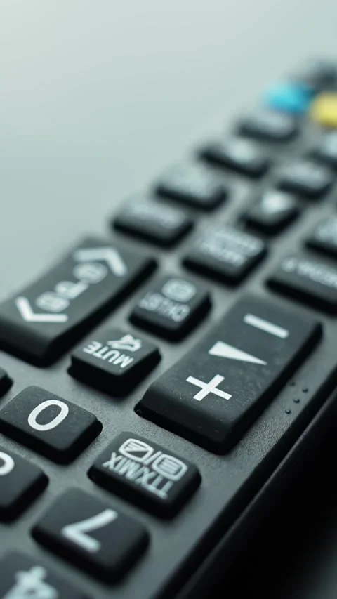 Vertical macro shot of a TV remote with a red power icon button in the Stock Footage 331324276
