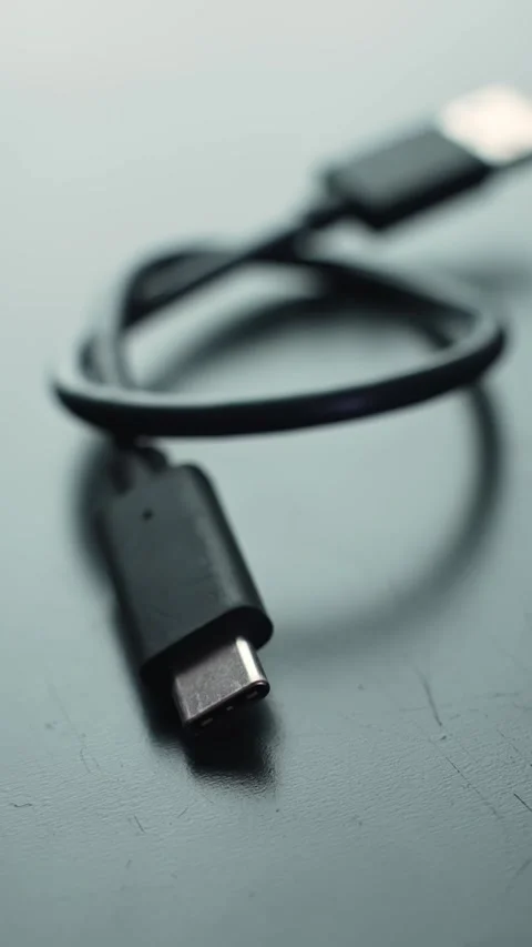 Vertical macro of USB-C to USB 3.0 adapter cable on a gray desk with soft bokeh Stock Footage 329480145