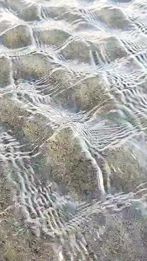 Vertical macro video of clear shallow water ripples moving over sand Stock Footage 340301747
