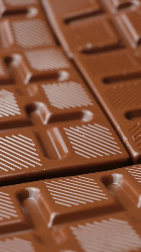 Vertical macro video of milk chocolate bars rotating slowly close up. 스톡 동영상 346205510