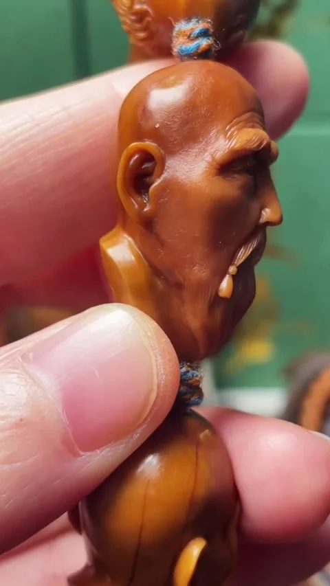 Vertical Macro Video of Traditional Hand-Carved Olive Pit Sculpture of an Ol Stock Footage 326080849