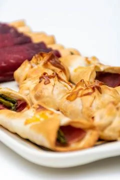 Vertical macro view of canaps and sachets with vegetables and ham and a pair  Stock Photos