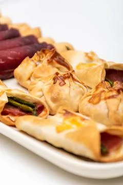 Vertical macro view of canaps and sachets with vegetables and ham and a pair  Stock Photos