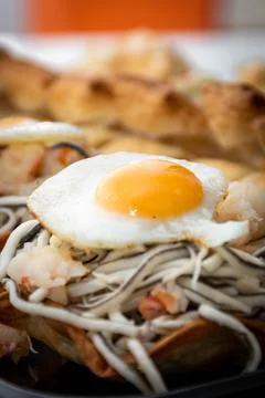 Vertical macro view of puff pastry with gluttony, quail egg and prawns with a Stock Photos