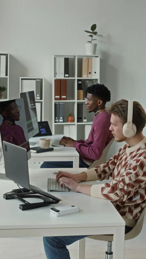 Vertical of Male Coder in Headphones Working on Computer in Open Plan Office Stock Footage 330131622
