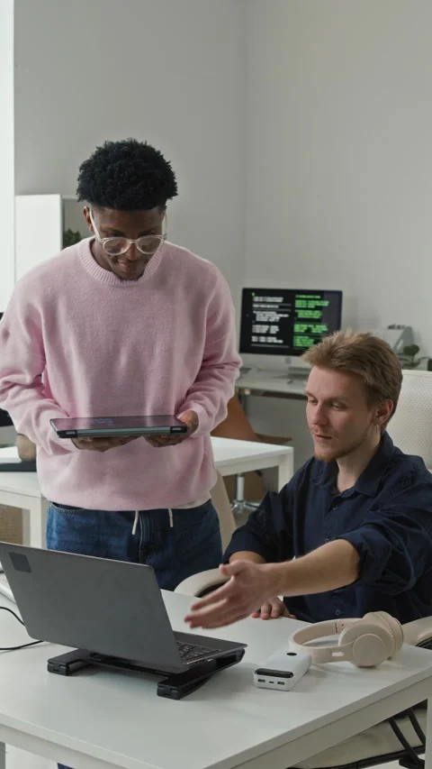 Vertical of Male IT Developer Supporting Colleague in Code Review in Office Stock Footage 330668357