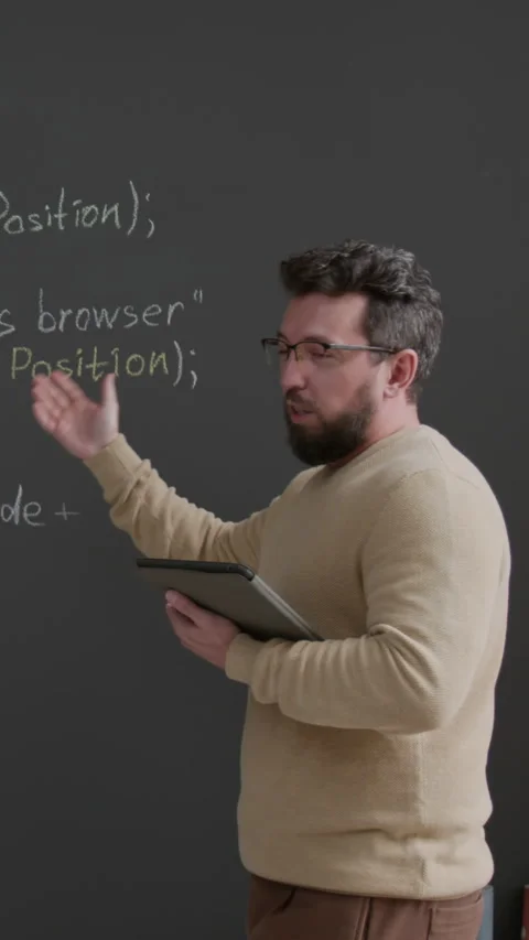 Vertical of Male Programming Teacher Explaining Code on Blackboard Stock Footage 318728862