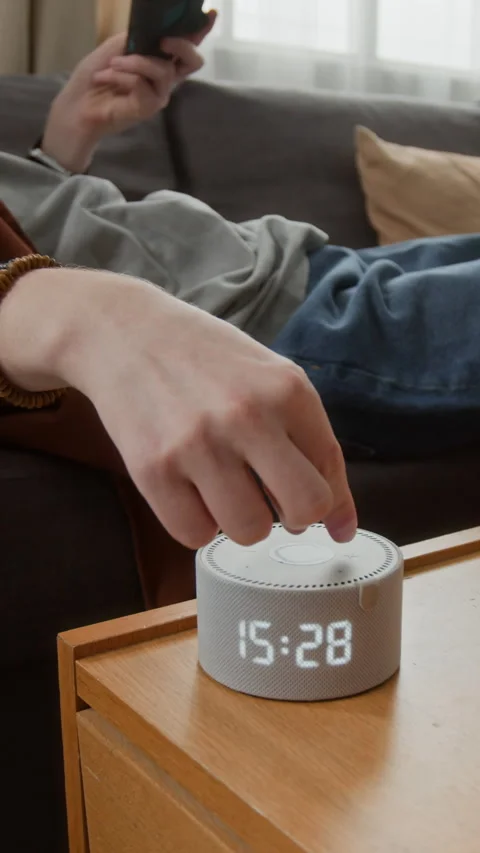 Vertical of Man Adjusting Smart Speaker Volume While Holding Game Controller Stock Footage 340772876