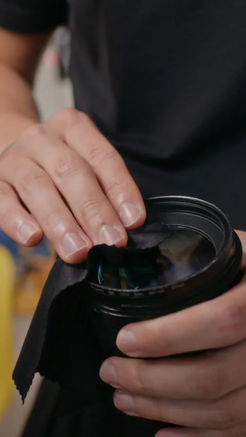 Vertical of Man Cleaning Professional Camera Lens with Microfiber Cloth Stock Footage 341947100