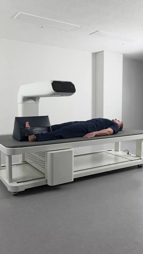 Vertical - Man doing full body DEXA scan in a modern medical clinic. Stock Footage 312328765