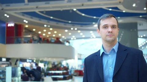 Vertical, man looking at camera and smiling in the lobby of a large supermarket Stock Footage 125919518
