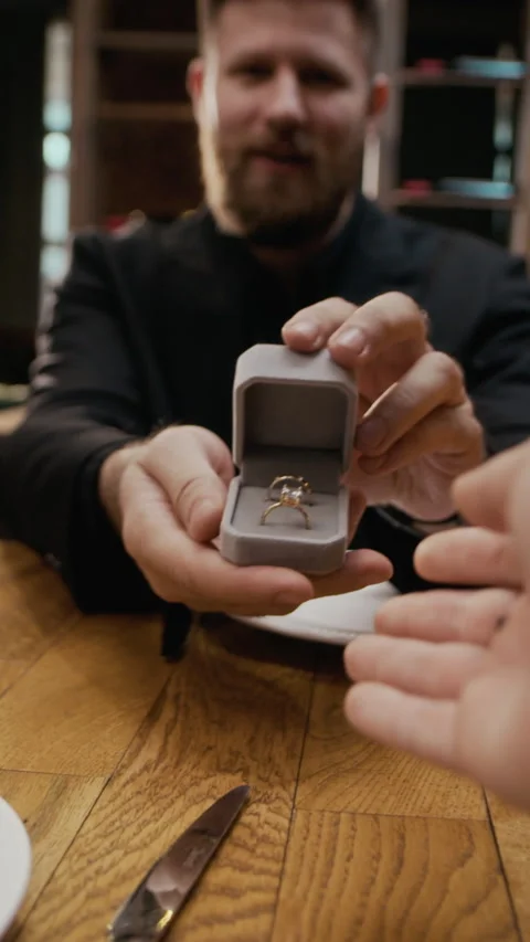 Vertical of Man Placing Engagement Ring on Finger during Restaurant Proposal Stock Footage 333394553