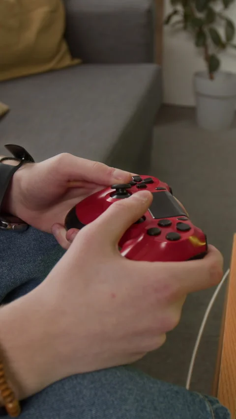 Vertical of Man Playing Video Game with Red Gamepad Controller Close-up Stock Footage 340772319