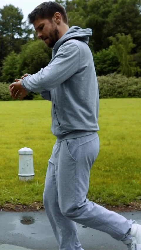 Vertical of Man running in forest woods training and look at computer clock on Stock Footage 278480741