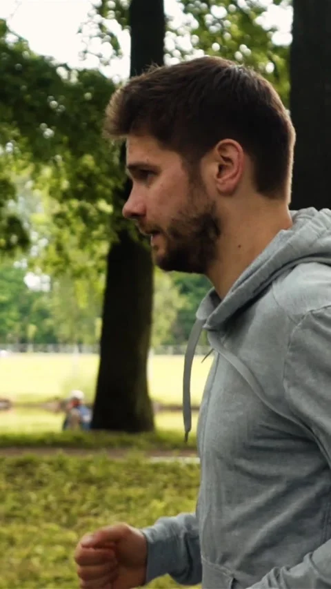 Vertical of Man running at the green summer park Stock Footage 278477736