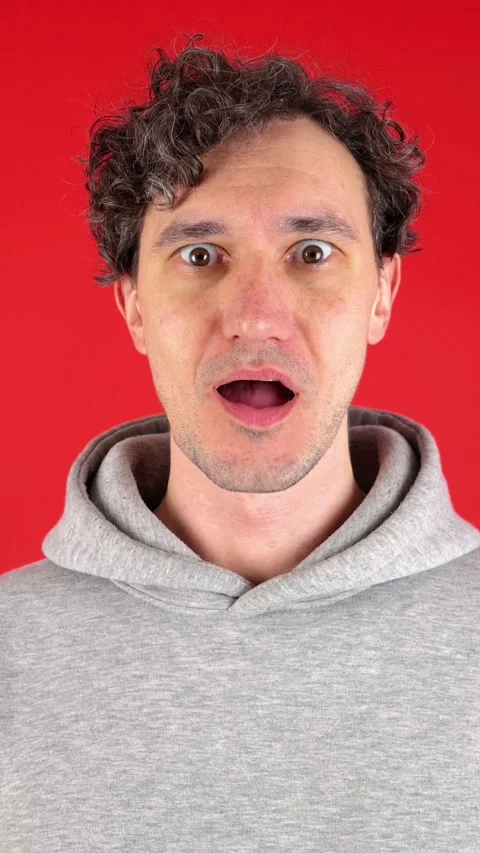 Vertical man, surprised, holding face hands and mouth open, pronouncing word wow 库存影片 304761925