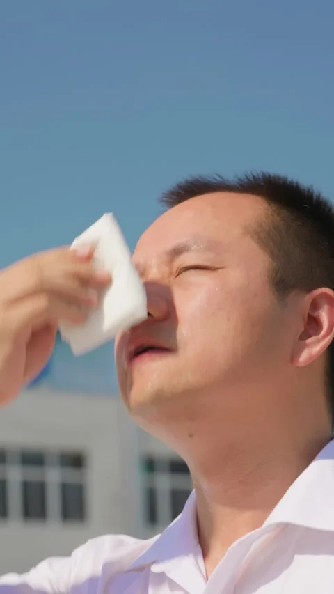 Vertical man wipes sweat off his face in sweltering summer heat. Vídeos de archivo 336037661