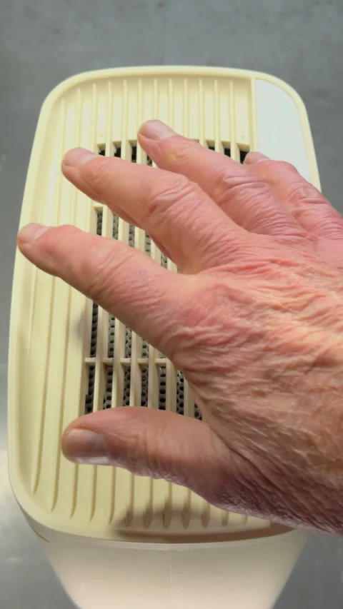 Vertical- Man’s hand pressing to start an appliance then testing the air flow. Stock-Footage 296099693