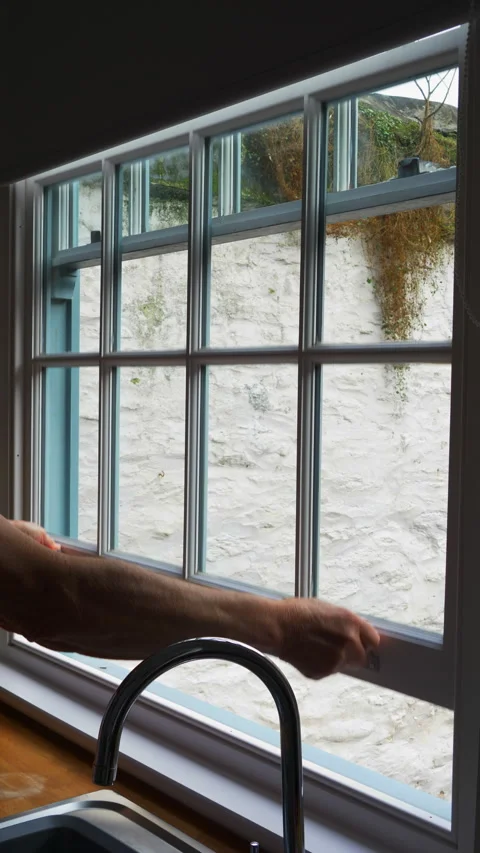 Vertical - A man’s hands lowering a traditional sash window to close it. Vídeos de archivo 288337329