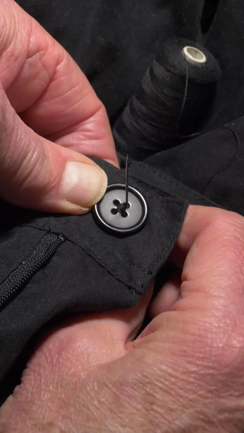 Vertical - Man’s hands using needle and thread to sew a button onto a garment. Vídeos de archivo 292160874
