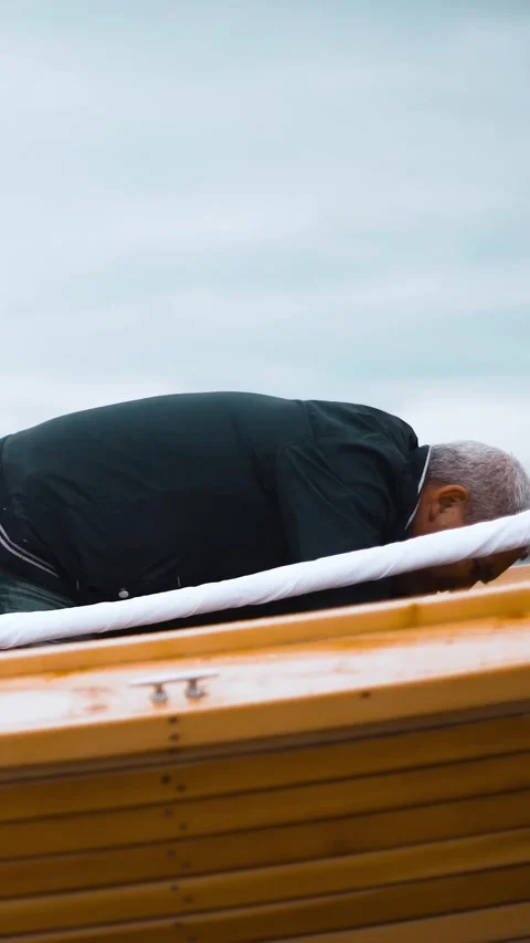 Vertical of Master and his assistant work on wooden sailboat on river Stock Footage 305512714
